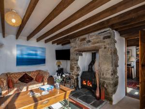 a living room with a stone fireplace at Trehaverock Cottage in Port Isaac