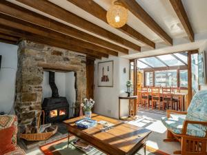 a living room with a stone fireplace and a table at Trehaverock Cottage in Port Isaac