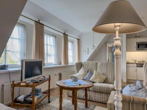a living room with a couch and a television at Mühlenhof, Keitum auf Sylt in Sylt