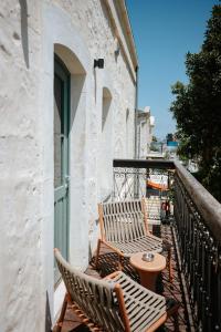 ein Balkon mit zwei Holzstühlen und einem Tisch in der Unterkunft Mila - Boutique Hotel in Haifa