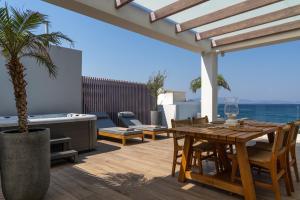 a patio with a table and chairs on a deck at Porto Perla in Kos
