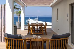 a dining room with a table and chairs and the ocean at Porto Perla in Kos