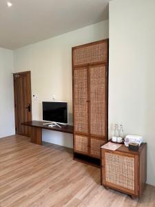 a living room with a television and a large door at Soleil House in Hue