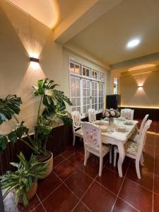 a dining room with a table and chairs and plants at Maison MAY Đà Lạt in Da Lat
