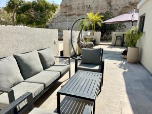 a couch and chairs sitting on a patio at אצל מאיה ואבשי Maya and Avshi in Neʼot HaKikar