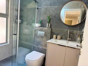 a bathroom with a shower and a toilet and a mirror at אצל מאיה ואבשי Maya and Avshi in Neʼot HaKikar