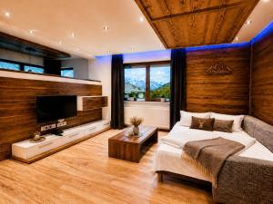 a bedroom with a large bed and a flat screen tv at Apart-Hotel Aurora Fiss in Fiss