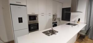 a white kitchen with a sink and a stove at T1 Luxgarden in Lamego
