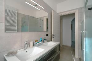 a white bathroom with a sink and a mirror at Villa Bianca in Perledo