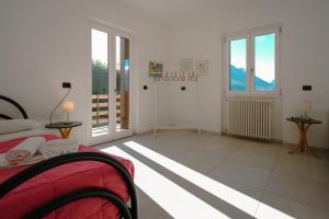 a bedroom with a bed and two tables and windows at Villa Bianca in Perledo