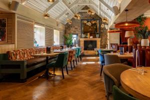 a restaurant with tables and chairs and a fireplace at The Mill House in Stewarton