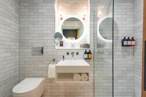 a bathroom with a sink and a toilet and a mirror at The Mill House in Stewarton +24 photos