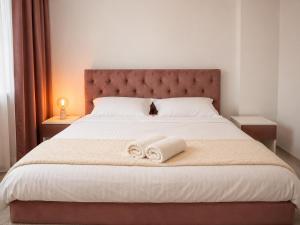 a bedroom with a large bed with towels on it at Nolia Apartments in Bucharest