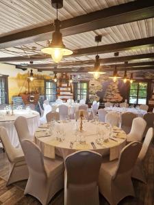a banquet hall with white tables and chairs at Kupiškio marių vila in Aukštupėnai