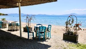 ein Tisch und Stühle am Strand in der Unterkunft Mati Kat Studios in Kala Nera