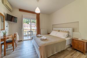 a bedroom with a bed and a desk and a television at Hotel Evridiki in Fourka
