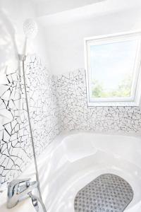 a bath tub in a bathroom with a window at La Maison Créative in La Madeleine