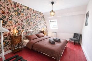 a bedroom with a bed with a floral wallpaper at La Maison Créative in La Madeleine