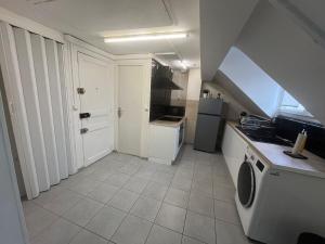 a small kitchen with a sink and a refrigerator at Spacieux studio in Montlhéry +1 photo