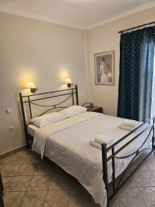 a bedroom with a large bed and a window at Amfitrion Apartments in Gythio