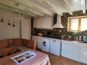 a kitchen with a table and a sink and a washing machine at L'Oursonnière de la Rende in Quérigut