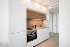 a kitchen with white cabinets and a stove at Casa Pedro Santa Clara in Torremolinos