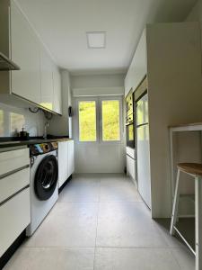 a kitchen with a washer and a washing machine at el AS del Puntal in Villaviciosa +20 photos