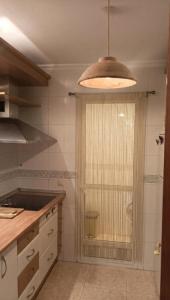 a kitchen with a window and a pendant light at Apartamento Belobodia in Cáceres +3 photos