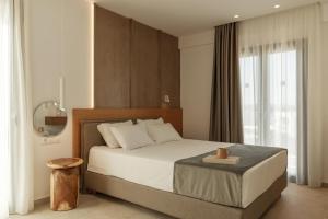a bedroom with a large bed with a wooden headboard at Nami Hotel & Suites in Stalís +83 photos