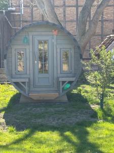 a play house with a door in the grass at Obstgarten im Warnetal- Campingfass Kobel in Gielde +9 photos