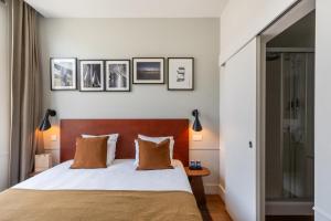 a bedroom with a bed and some pictures on the wall at A Place Antwerp - Boutique Hotel Emile in Antwerp