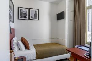 a bedroom with a bed and a desk and a tv at A Place Antwerp - Boutique Hotel Emile in Antwerp
