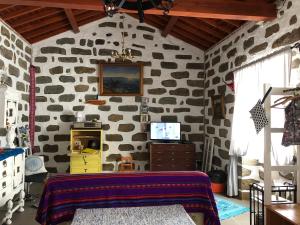 a room with a stone wall with a bed in it at Casa Auri in Faial da Terra