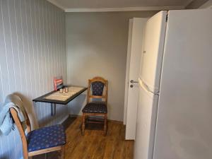 a small kitchen with a table and a refrigerator at Fjord & Fjell Idyll in Tunheim +17 photos