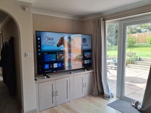 a living room with a large flat screen tv at Marley Farm Bungalow in Deal