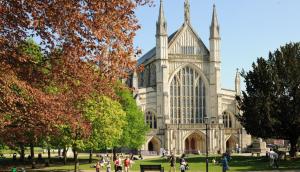 a group of people walking in front of a cathedral at Garden room, central Winchester in Winchester +1 photo