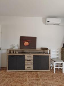 a large entertainment center with a television on top of it at La Caseta Dels Avis in Sant Jaume d'Enveja