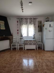 a living room with a refrigerator and a table and chairs at La Caseta Dels Avis in Sant Jaume d'Enveja +21 photos