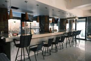a bar with a row of chairs in a kitchen at Collection O Luna Hotel Pattaya in Pattaya