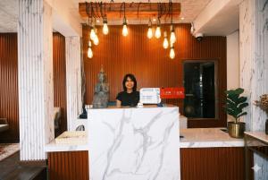 a woman is standing behind a counter in an office at Collection O Luna Hotel Pattaya in Pattaya +17 photos