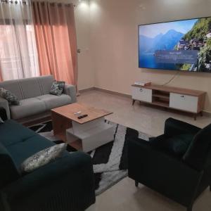 a living room with couches and a flat screen tv at You Royal in Dakar