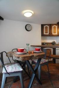 a kitchen with a table and two chairs and a clock at Dairy Cottage in Hennock