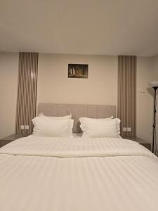 a large bed with white sheets and pillows at استديو سفاري الخبر in Al Khobar
