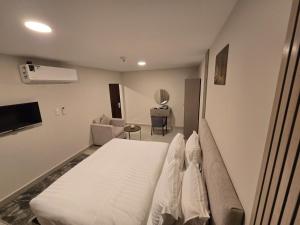 a bedroom with a white bed and a couch at استديو سفاري الخبر in Al Khobar