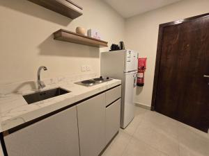 a kitchen with a sink and a refrigerator at استديو سفاري الخبر in Al Khobar