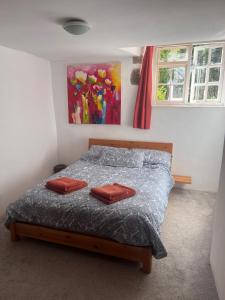a bedroom with a bed with two red pillows on it at Dairy Cottage in Hennock