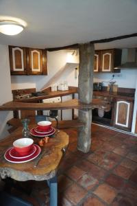 a kitchen with wooden tables with plates and bowls at Dairy Cottage in Hennock