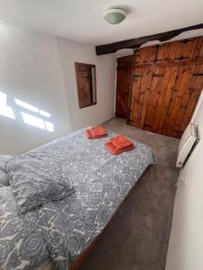 a bedroom with a bed and wooden cabinets at Dairy Cottage in Hennock +7 photos
