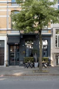 a tree in front of a building with benches at A Place Antwerp - Boutique Hotel Emile in Antwerp