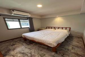 a bedroom with a bed in a room with a window at Collection O Luna Hotel Pattaya in Pattaya